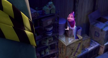 Movie still from “Shark Tale” (2004), directed by Vicky Jenson – A purple stuffed animal sitting on top of a shelf in a room; Medium shot, High angle