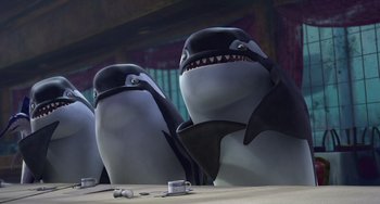 Movie still from “Shark Tale” (2004), directed by Vicky Jenson – A couple of sharks that are standing in a room; Medium shot, Low angle