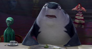 Movie still from “Shark Tale” (2004), directed by Vicky Jenson – A cartoon shark sitting in front of a plate of food; Medium shot, High angle