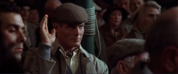 Movie still from “The Remains of the Day” (1993), directed by James Ivory – A man wearing a brown hat and a beige jacket; Close Up shot, Over the shoulder angle