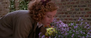 Movie still from “The Remains of the Day” (1993), directed by James Ivory – A woman smelling flowers in a flower bed; Close Up shot, Low angle