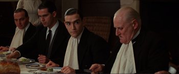 Movie still from “The Remains of the Day” (1993), directed by James Ivory – A group of men sitting around a table; Medium shot, Over the shoulder angle