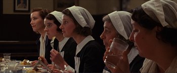 Movie still from “The Remains of the Day” (1993), directed by James Ivory – A group of women wearing white hats and holding silverware; Medium shot, Low angle