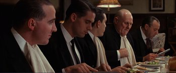 Movie still from “The Remains of the Day” (1993), directed by James Ivory – A group of men sitting at a table looking at computers; Medium shot, Low angle