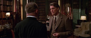 Movie still from “The Remains of the Day” (1993), directed by James Ivory – A man in a suit and tie talking to another man in a suit and tie; Medium shot, Over the shoulder angle
