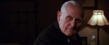 Movie still from “The Remains of the Day” (1993), directed by James Ivory – An old man with a white beard is looking at the camera; Close Up shot, Low angle