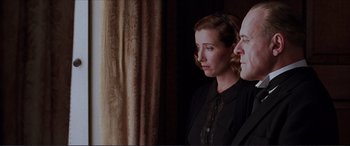 Movie still from “The Remains of the Day” (1993), directed by James Ivory – A man and a woman are standing next to each other; Medium shot, Low angle