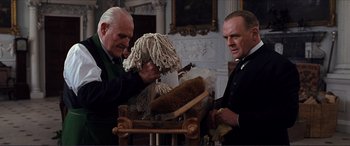 Movie still from “The Remains of the Day” (1993), directed by James Ivory – Two men are working with a mop in a room; Medium shot, Low angle