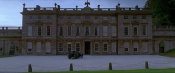Movie still from “The Remains of the Day” (1993), directed by James Ivory – An old car parked in front of a large building; Extreme Wide shot, Low angle