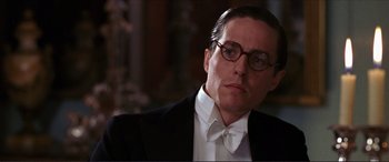 Movie still from “The Remains of the Day” (1993), directed by James Ivory – A person wearing glasses and a suit; Close Up shot, Low angle