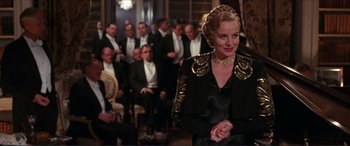 Movie still from “The Remains of the Day” (1993), directed by James Ivory – A woman standing in front of a group of men; Medium shot, Over the shoulder angle