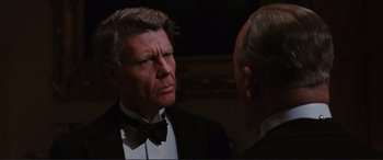 Movie still from “The Remains of the Day” (1993), directed by James Ivory – Two men in tuxedos talking to each other; Close Up shot, Over the shoulder angle