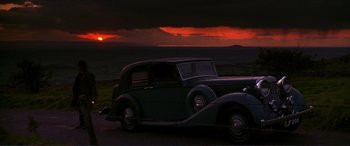 Movie still from “The Remains of the Day” (1993), directed by James Ivory – An old car parked on the side of a road; Extreme Wide shot, Low angle