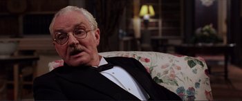 Movie still from “The Remains of the Day” (1993), directed by James Ivory – An older man wearing a suit and tie; Close Up shot, Low angle