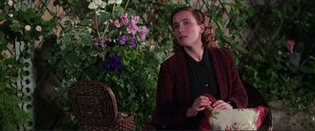 Movie still from “The Remains of the Day” (1993), directed by James Ivory – A woman sitting in front of a flower bush; Medium shot, Over the shoulder angle