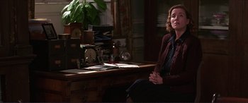 Movie still from “The Remains of the Day” (1993), directed by James Ivory – A woman sitting in front of a desk in a room; Medium shot, Over the shoulder angle