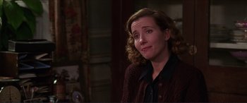 Movie still from “The Remains of the Day” (1993), directed by James Ivory – A woman with curly hair is smiling for the camera; Close Up shot, Over the shoulder angle