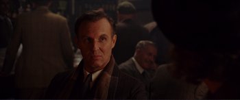 Movie still from “The Remains of the Day” (1993), directed by James Ivory – A person wearing a suit and tie; Close Up shot, Over the shoulder angle