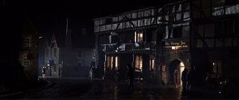 Movie still from “The Remains of the Day” (1993), directed by James Ivory – Two people standing in front of a building at night; Extreme Wide shot, Low angle