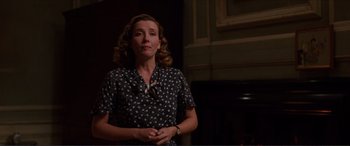 Movie still from “The Remains of the Day” (1993), directed by James Ivory – A woman standing in front of a fireplace in a room; Medium shot, Low angle