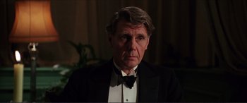 Movie still from “The Remains of the Day” (1993), directed by James Ivory – An older man in a black suit and a bow tie; Close Up shot, Over the shoulder angle