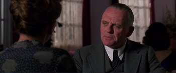 Movie still from “The Remains of the Day” (1993), directed by James Ivory – An older man wearing a suit and a tie; Close Up shot, Over the shoulder angle