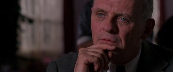 Movie still from “The Remains of the Day” (1993), directed by James Ivory – A person wearing a suit and tie; Close Up shot, Over the shoulder angle