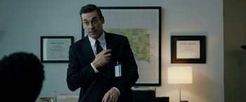 Movie still from “The Report” (2019), directed by Scott Z. Burns – A man in a suit and tie holding a phone; Medium shot, Over the shoulder angle