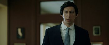 Movie still from “The Report” (2019), directed by Scott Z. Burns – A man in a suit and tie standing in front of a window; Close Up shot, Over the shoulder angle