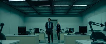 Movie still from “The Report” (2019), directed by Scott Z. Burns – A man and a woman standing next to each other in a room; Wide shot, Low angle