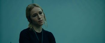 Movie still from “The Report” (2019), directed by Scott Z. Burns – A woman with blonde hair wearing a black shirt; Close Up shot, Over the shoulder angle