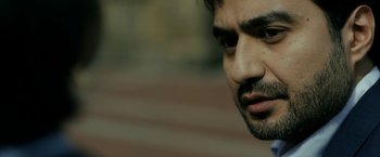 Movie still from “The Report” (2019), directed by Scott Z. Burns – A man's face with a blurry background; Extreme Close Up shot, Low angle