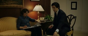 Movie still from “The Report” (2019), directed by Scott Z. Burns – A man and a woman sitting in a living room; Medium shot, High angle