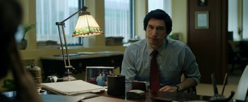 Movie still from “The Report” (2019), directed by Scott Z. Burns – A man sitting at a desk in front of a lamp; Medium shot, Over the shoulder angle