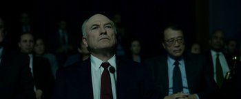 Movie still from “The Report” (2019), directed by Scott Z. Burns – A man in a suit and tie looking up; Close Up shot, Low angle