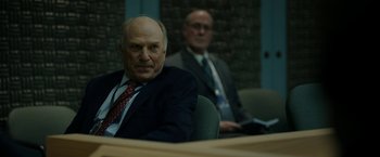 Movie still from “The Report” (2019), directed by Scott Z. Burns – A man in a suit sitting in front of another man in a suit; Medium shot, Over the shoulder angle