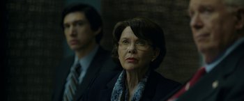 Movie still from “The Report” (2019), directed by Scott Z. Burns – An older woman wearing glasses and a suit; Close Up shot, Low angle