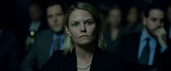 Movie still from “The Report” (2019), directed by Scott Z. Burns – A person wearing a suit and pearls; Close Up shot, Over the shoulder angle