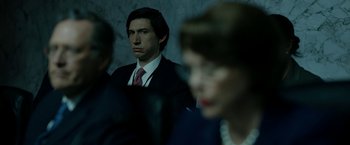 Movie still from “The Report” (2019), directed by Scott Z. Burns – A man in a suit and tie standing next to a woman in a suit; Medium shot, Over the shoulder angle