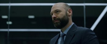 Movie still from “The Report” (2019), directed by Scott Z. Burns – A man in a suit and tie looking to his left; Close Up shot, Low angle