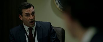 Movie still from “The Report” (2019), directed by Scott Z. Burns – A man wearing a suit and tie talking to someone; Close Up shot, Over the shoulder angle