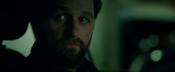 Movie still from “The Report” (2019), directed by Scott Z. Burns – A person with a beard looking at the camera; Close Up shot, Low angle