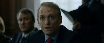 Movie still from “The Report” (2019), directed by Scott Z. Burns – A person wearing a suit and tie; Close Up shot, Over the shoulder angle