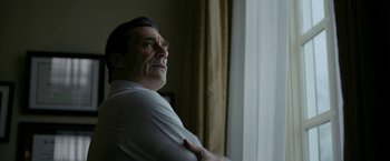 Movie still from “The Report” (2019), directed by Scott Z. Burns – A man standing in front of a window looking out; Close Up shot, Low angle