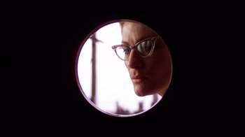 Movie still from “The Right Stuff” (1983), directed by Philip Kaufman – A woman wearing glasses looking into a round mirror; Close Up shot, Low angle