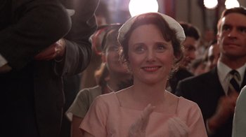 Movie still from “The Right Stuff” (1983), directed by Philip Kaufman – A woman in a pink dress and a white hat; Close Up shot, Over the shoulder angle