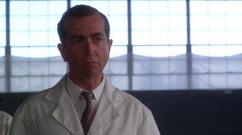 Movie still from “The Right Stuff” (1983), directed by Philip Kaufman – A man in a white lab coat and a tie; Close Up shot, Low angle