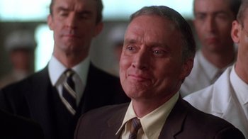 Movie still from “The Right Stuff” (1983), directed by Philip Kaufman – A man wearing a suit and tie in front of another man in a suit and tie; Close Up shot, Low angle