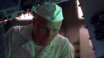 Movie still from “The Right Stuff” (1983), directed by Philip Kaufman – A man wearing a white hat in a room; Close Up shot, Low angle