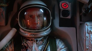 Movie still from “The Right Stuff” (1983), directed by Philip Kaufman – A man wearing a space suit and helmet; Close Up shot, Overhead angle